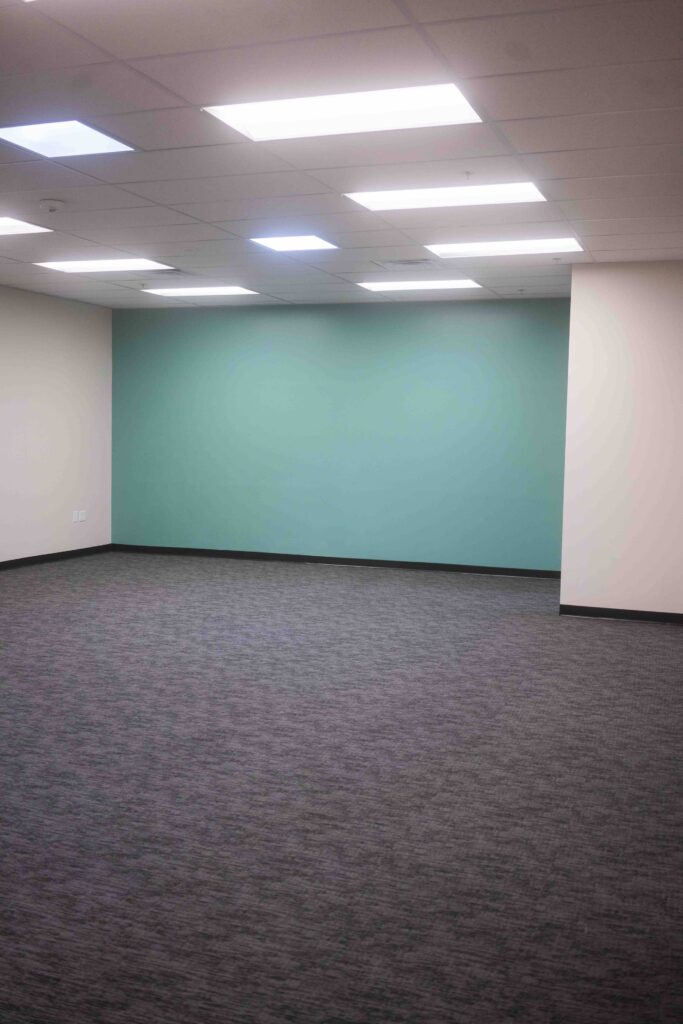 Vertical view of a finished room showing a teal accent wall and support column