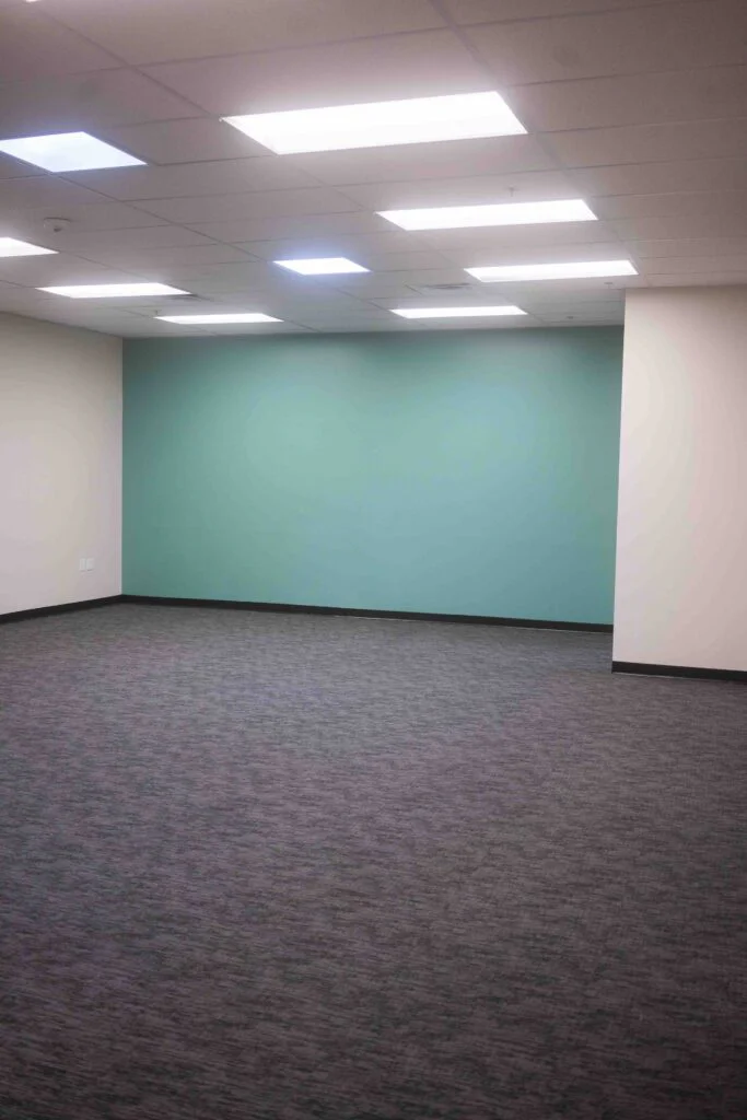 Vertical view of a finished room showing a teal accent wall and support column