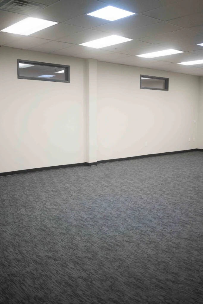 Corner view of a renovated interior room with small transom windows near the ceiling