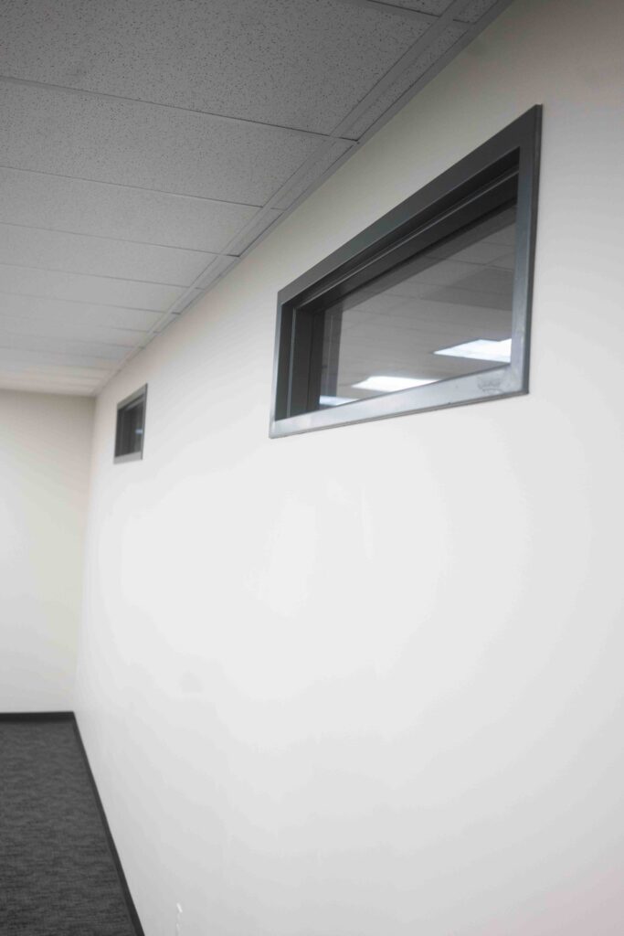 Corridor wall featuring two small transom windows and painted trim