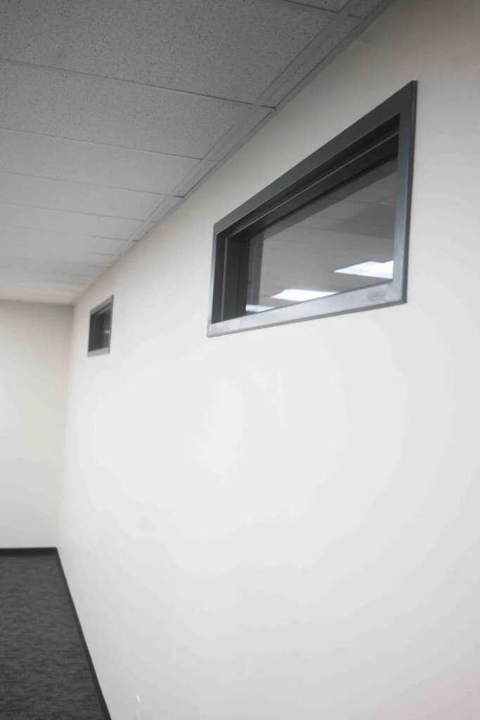 Corridor wall featuring two small transom windows and painted trim