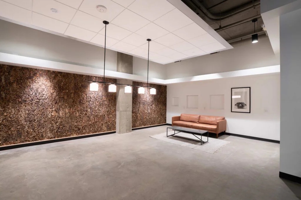 Leather sofa and coffee table in a lounge area with a textured cork accent wall
