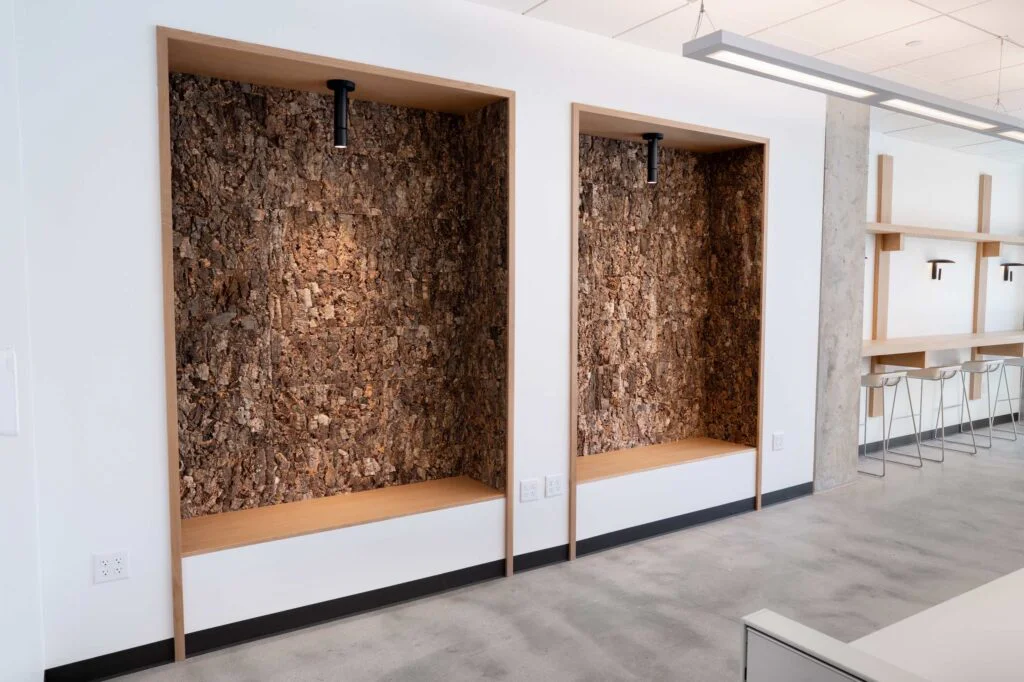 Two built-in bench seating nooks with cork-textured walls and pendant lights