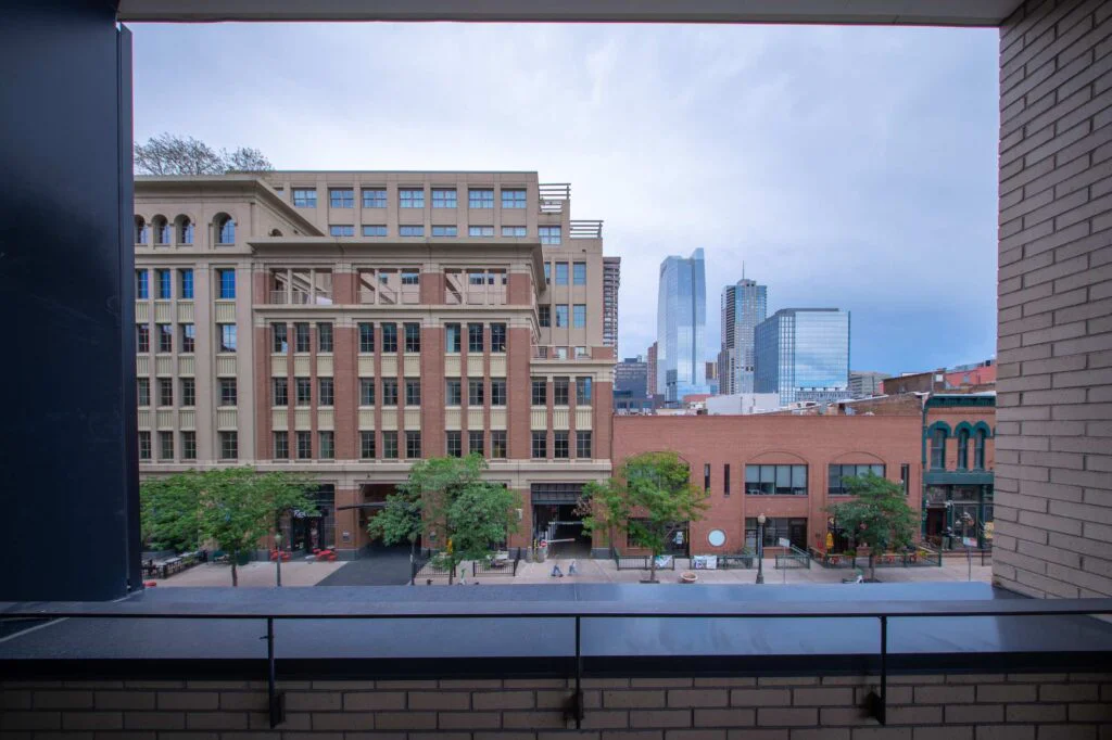 View from an office balcony looking out at neighboring brick and glass buildings in the downtown skyline