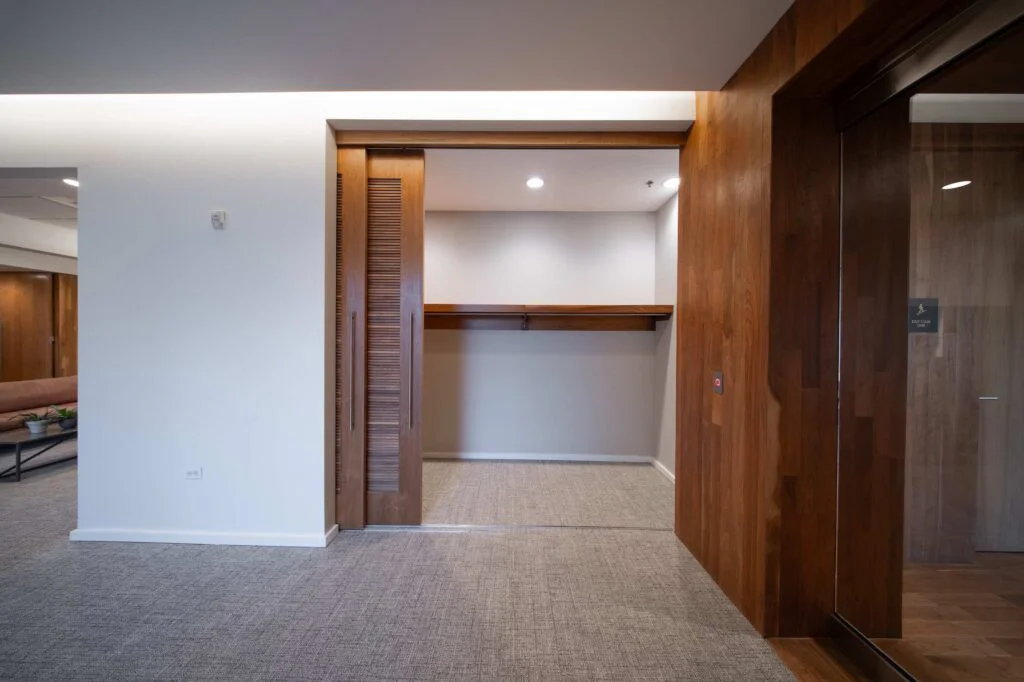 Office corridor with a sliding wood panel door open to a built-in storage nook