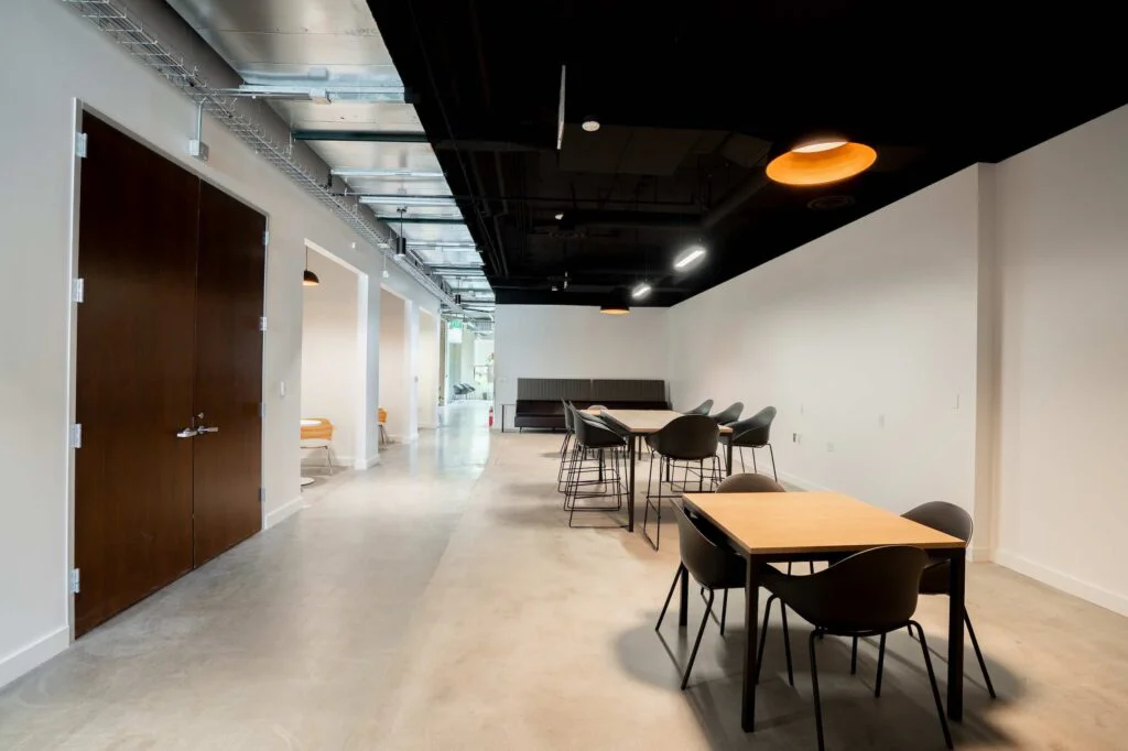 Office corridor with a dark wood door, seating alcoves, and booth-style bench seating