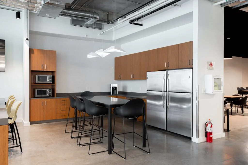 Break room kitchen with stainless steel refrigerators, microwaves and a seating island