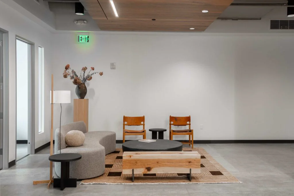 Reception lounge with a sofa, leather chairs, a wood ceiling accent and dried flower arrangement