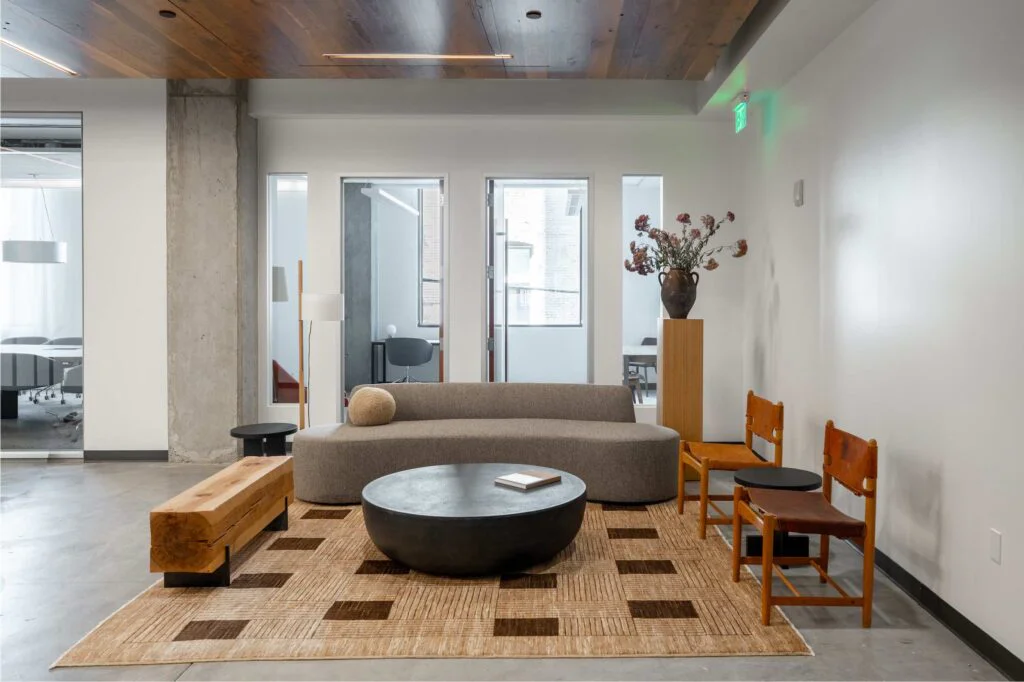 Curved sofa, leather chairs and a live-edge wood bench in an office lounge
