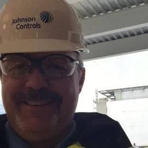 Rhett Davis wearing a hard hat with a Johnson Controls logo at a job site
